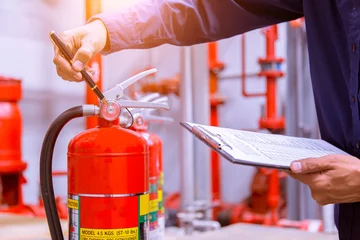 Rolgordijnen Ingenieur controleert industrieel vuurleidingssysteem, brandalarmcontroller, brandmelder, antibrand. Systeem gereed In geval van brand. © A Stockphoto