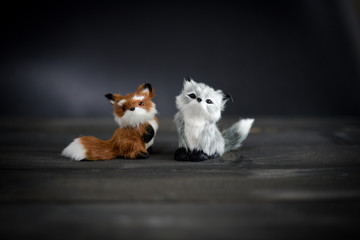 cute small foxes toy simulation fox doll, light brown and grey on black wooden table