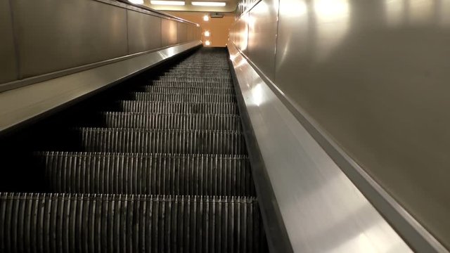 Riding up on train, tube or underground escalator to the top end into the station