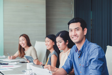 Smiling businessman with colleagues in meeting room