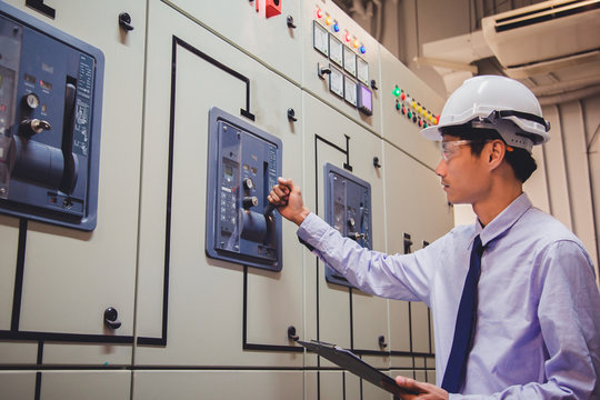 Engineer is check voltage or current by voltmeter in control panel of power plant.