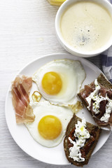 breakfast of scrambled eggs with jerky meat, juice and coffee on a white background top view.