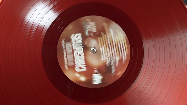 Top view of a musical DJ player on a rotating red vinyl plate. The moment of a spinning vinyl plate close up. Loop