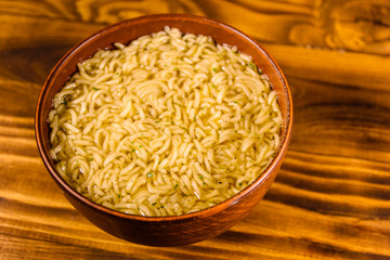Ceramic bowl with prepared instant noodles on wooden table