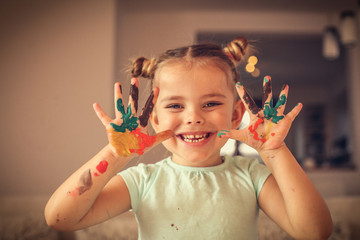 Creative child. Little girl painting hands.