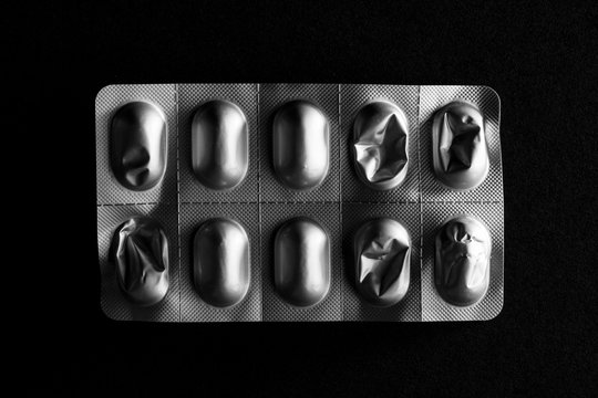 Used medicine foil packaging on black