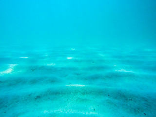 Obraz premium Underwater scene with sunlight through water surface to bottom of sand side