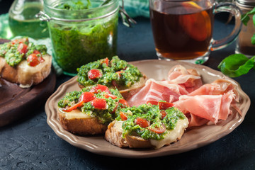Bruschetta with fresh pesto, mozzarella and cherry tomatoes on a plate
