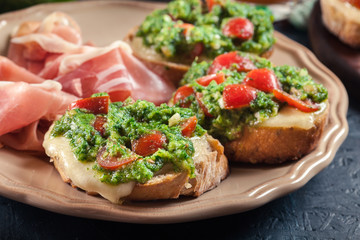 Bruschetta with fresh pesto, mozzarella and cherry tomatoes on a plate