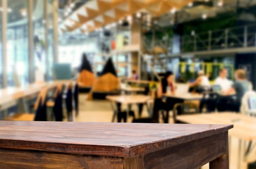 Selected focus empty brown wooden table and Coffee shop or restaurant blur background with bokeh image. for your photomontage or product display.