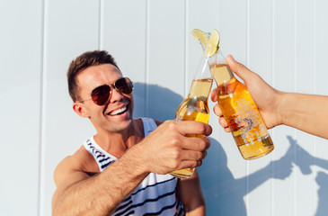 Attractive man making a toast with beer, outdoors.