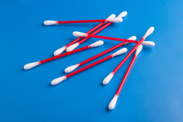 Set of cotton swabs isolated on blue background, cotton swabs red and white.