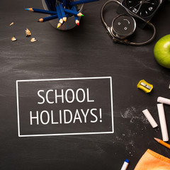 text school holidays and school supplies on chalk Board top view
