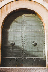 old green doors in building in Rome, Italy
