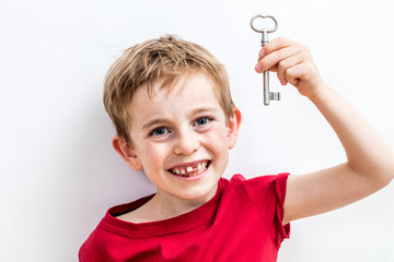 giggling toothless child holding key for concept of fun idea