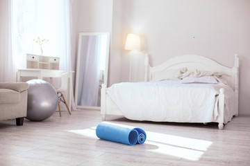 Healthy exercises. Blue folded yoga mat lying on the floor