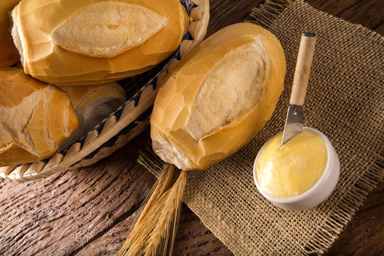 Basket of "French bread", traditional Brazilian bread with butter on wood background.