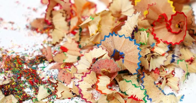Multi-colored pencil shavings drop on the white background