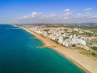 Fototapeta na wymiar Wide sandy beach in touristic Quarteira and Vilamoura, Algarve, Portugal