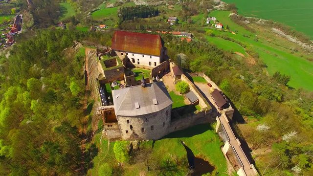 Drone flight around Tocnik Castle in blooming orchard. A royal chateau of Wenceslas IV from the 14th century, adjusted in the Renaissance and the Baroque styles. Famous Czech monument from above. 