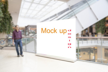 Blank standing sign with copy space for text messege or mock up content in blur department store or shopping mall background.Clipping path include.