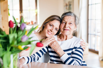 An elderly grandmother with an adult granddaughter at home.