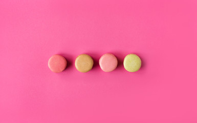 Colored macaroons on a pink  background , colorful almond cookies, pastel colors, vintage card, top view