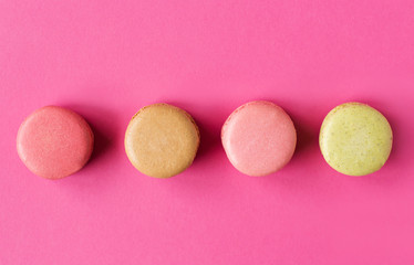 Colored macaroons on a pink  background , colorful almond cookies, pastel colors, vintage card, top view