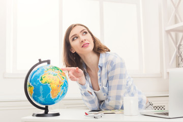 Woman dreaming about travel, looking at globe