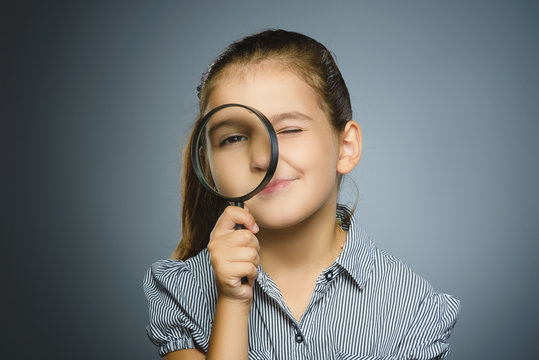 Girl See Through Magnifying Glass, Kid Eye Looking with Magnifier Lens over Gray