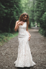 Fototapeta na wymiar Beautiful bride posing in wedding dress outdoors