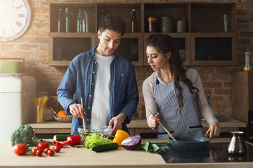 Happy couple cooking healthy dinner together
