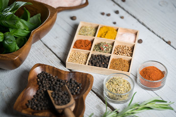 colorful fresh herbs and spices assortment on a white wooden background