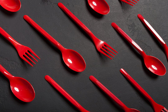 Top view on plastic forks and spoons on black background