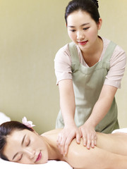 Obraz na płótnie Canvas young asian masseuse performing massage on woman