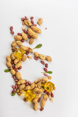 Natural peanut butter with oil in a glass jar and peanuts