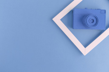 Flat lay of blue vintage camera and photo frame background