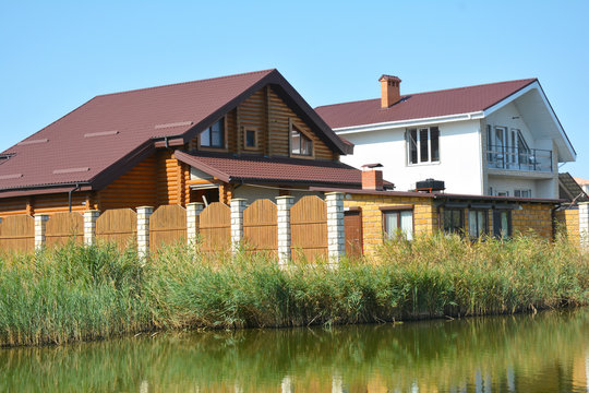 Wooden house construction with metal roof on the river bank with beautiful view.