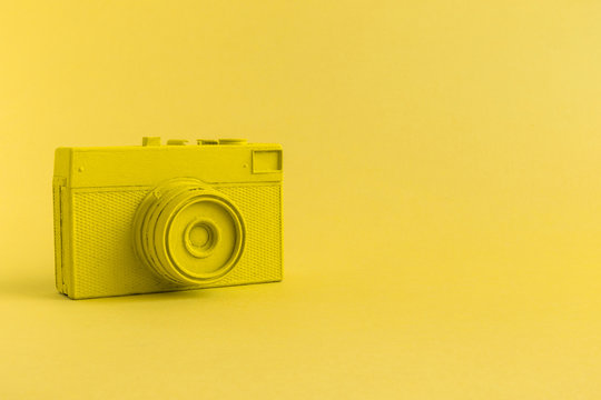 Flat lay of yellow colored retro camera surrealism abstract concept
