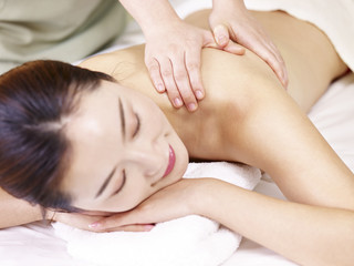 Obraz na płótnie Canvas beautiful young asian woman receiving massage in spa salon