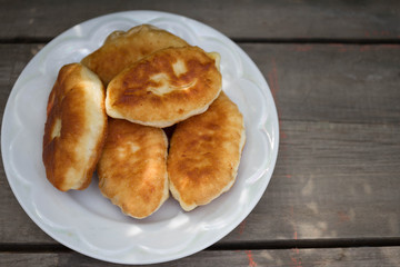 Fresh baked pastries filled with vegetables and cheese on wooden backgroun