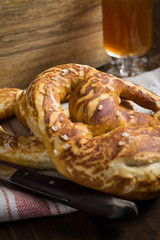Homemade Pretzel with Sea Salt and Glass of Beer on Rustic Wooden Table