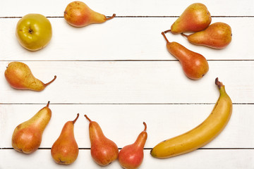 Top view of ripe yellow orange fruits lying on white wooden plank background with copy space in center