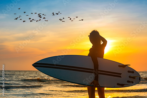 Silhouette Of Woman Holding Surfboard Standing Disappoint In