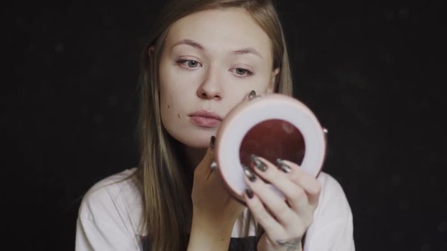 A woman tones her face with a proofreader. She does makeup. Portrait. Close-up. 4k