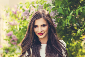 Naklejka premium Spring portrait of beautiful young woman with long healthy hair outdoor. Female model in park outdoors, cute face closeup