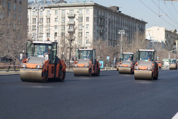 Heavy vibration roller compactors repairs the road on the asphalt surface on the road in the big city street in Moscow, russia