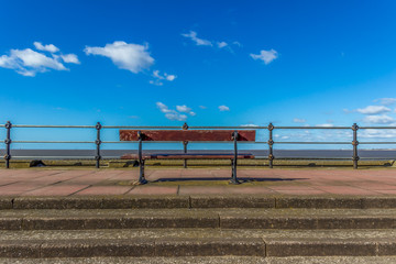Fototapeta na wymiar Promenade seaside bench on sunny day