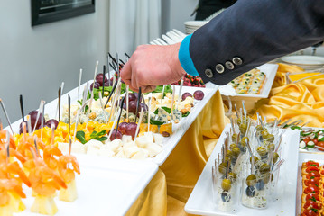 Catering buffet table with food and snacks for guests of the event. Group of people in all you can eat. Dining Food Celebration Party Concept. Service at business meeting, weddings. Selective focus.