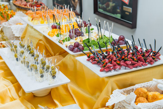 Catering table with dishes and snacks on the business event in the hotel hall. Service at business meeting, party, weddings. Selective focus, space for text.
